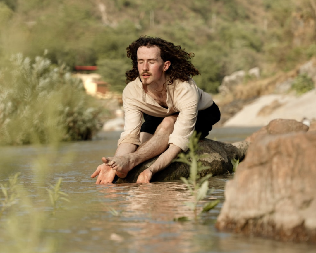 Solo yoga practice on the banks of the River Ganga in Rishikesh, embracing peace and spirituality
